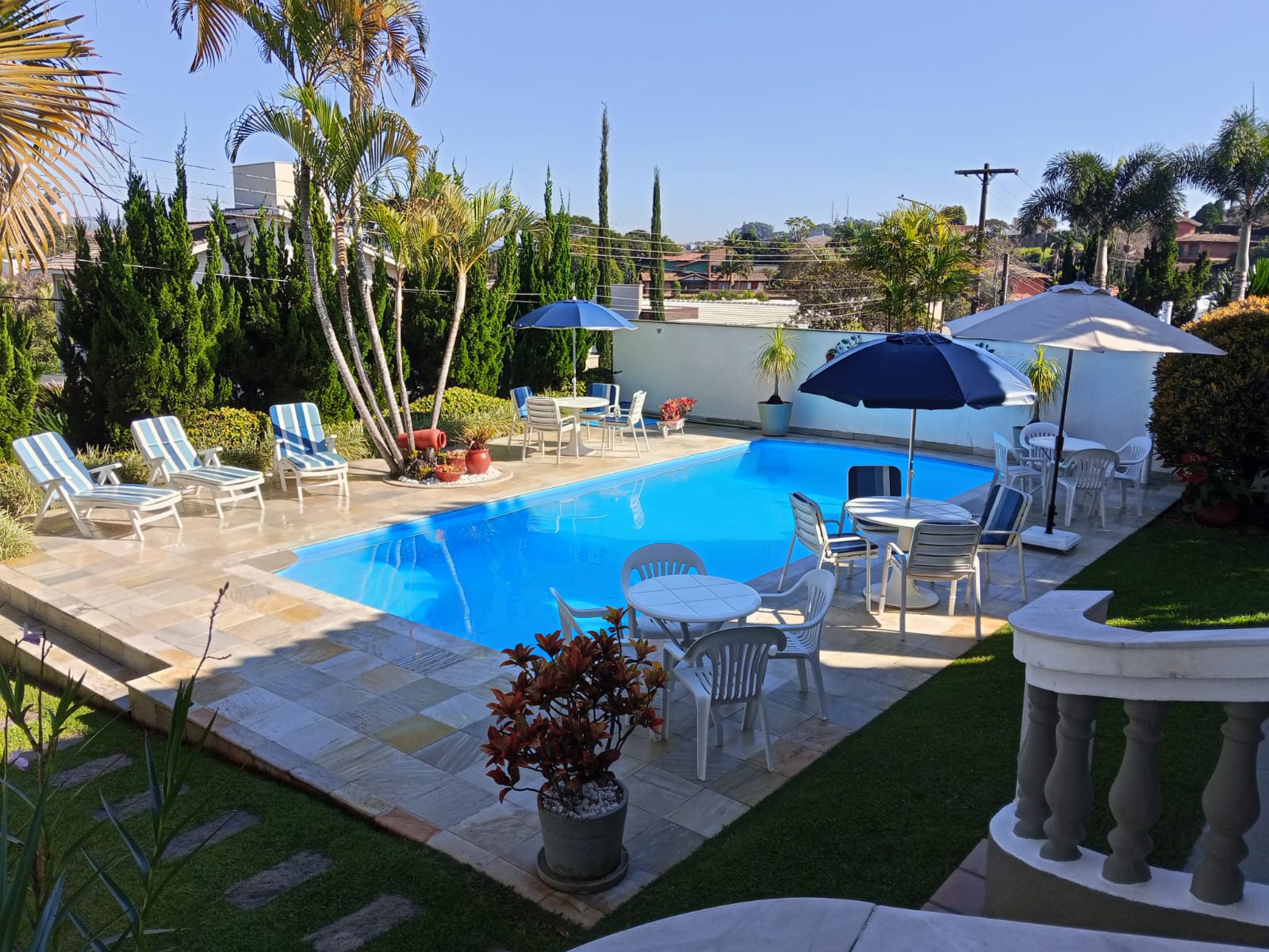 Piscina com espreguiçadeiras e paisagismo