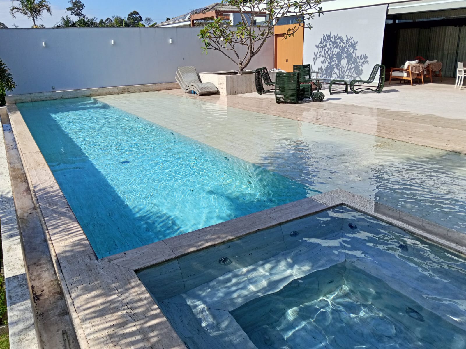 Piscina moderna com raia e deck de madeira